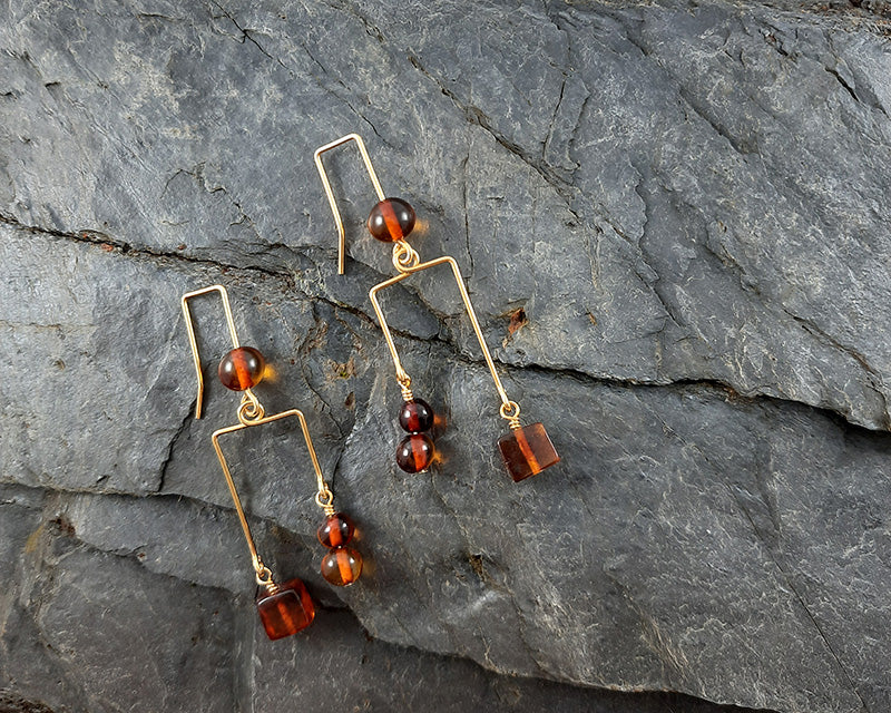 A pair of Blodughadda goldplated earrings laying on a rock