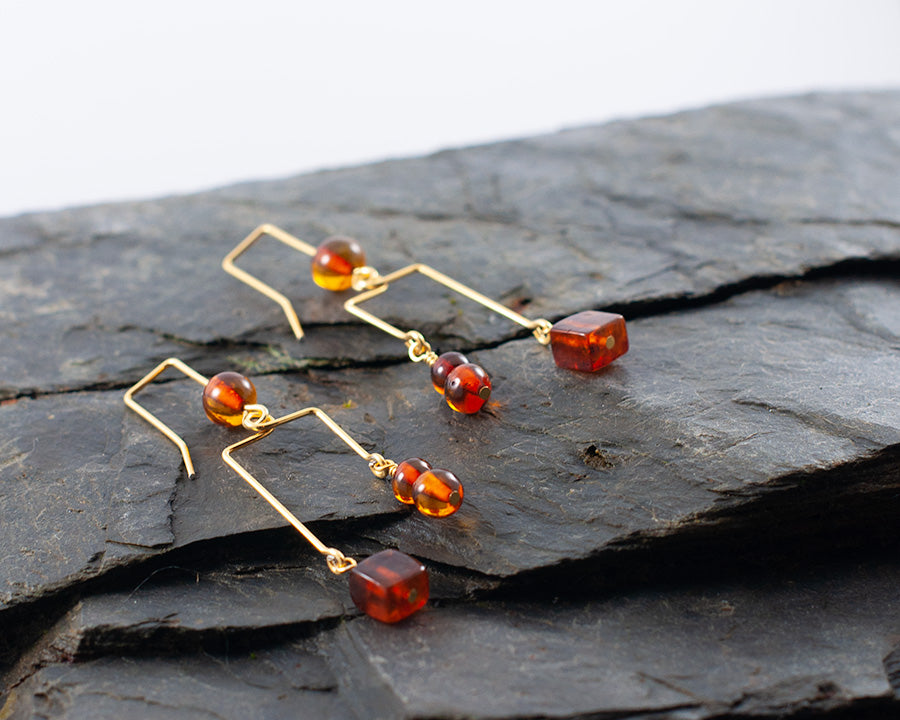 A pair of Blodughadda goldplated earrings laying on a rock