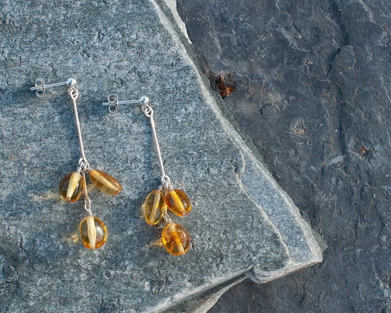 A pair of Himminglava sterling silver earrings laying on a rock i the sun.