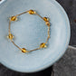 Sjavn goldplated bracelet in a blue ceramic bowl. picture taken from above.
