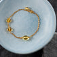 Herving goldplated bracelet laying in a blue ceramic bowl.